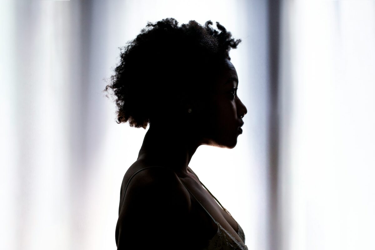 Silhouette of a Black woman. Photo credit: Photo @actionvance via Unsplash